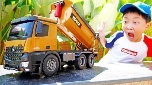 'Yejun tests toy trucks and excavators at playground'